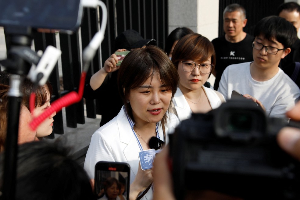 Teresa Xu fala com a imprensa do lado de fora do tribunal em Pequim — Foto: Florence Lo/REUTERS