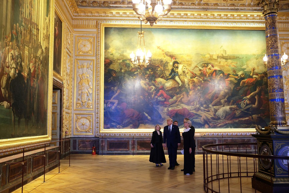 Emmanuel Macron, Brigitte Macron e Donald Trump durante tour pelo Palácio de Versalhes, em 17 de junho de 2026 — Foto: Anna Moneymaker/Pool via Reuters