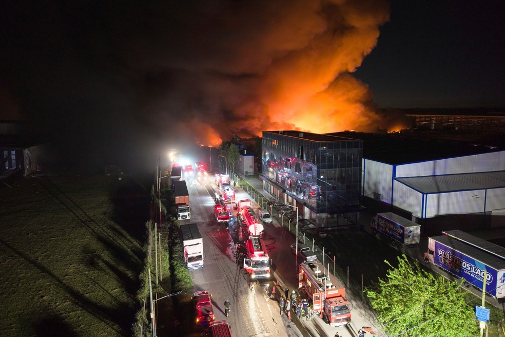 Bombeiros trabalham para controlar um incêndio em um parque industrial em Ezeiza, Argentina — Foto: AP/Rodrigo Abd