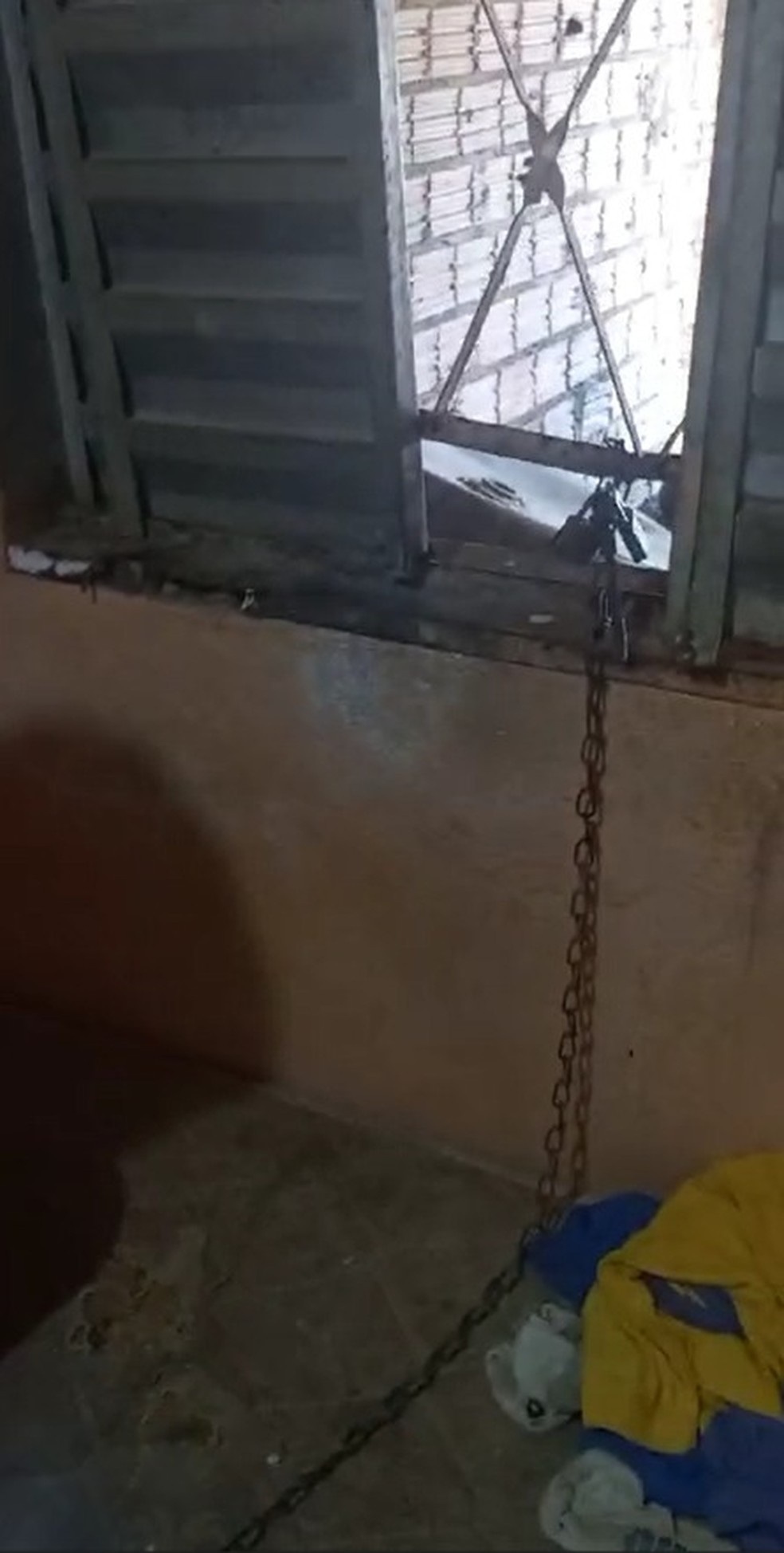 Menino de 10 anos estava preso por corrente trancada com dois cardeados na janela da residência em Porto Velho (RO)  — Foto: Reprodução/PM