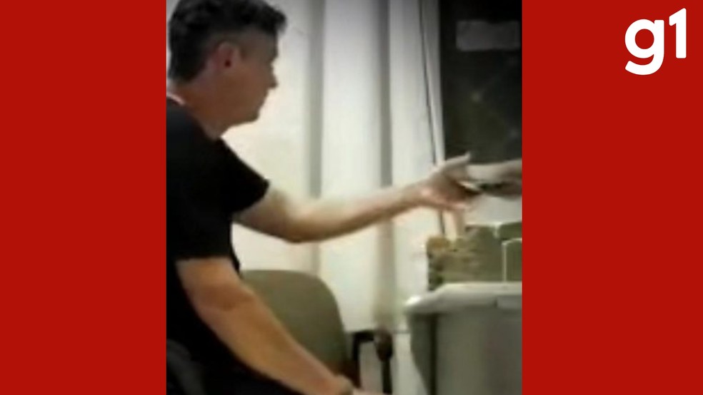 No vídeo, Rogério recebe uma quantia em cédulas e coloca o dinheiro no bolso direito da calça, conforme o documento — Foto: Reprodução