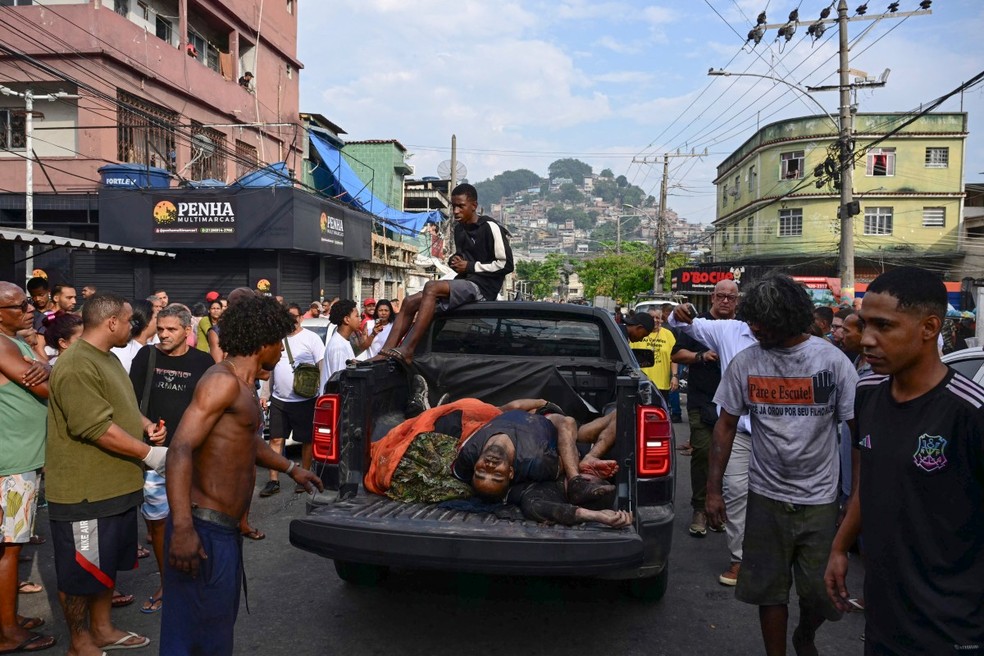 Moradores levam corpos achados em mata para a Praça São Lucas, na favela Vila Cruzeiro, no complexo da Penha, no Rio de Janeiro, Brasil, em 29 de outubro de 2025, após a Operação Contenção. — Foto: Pablo Porciuncula / AFP