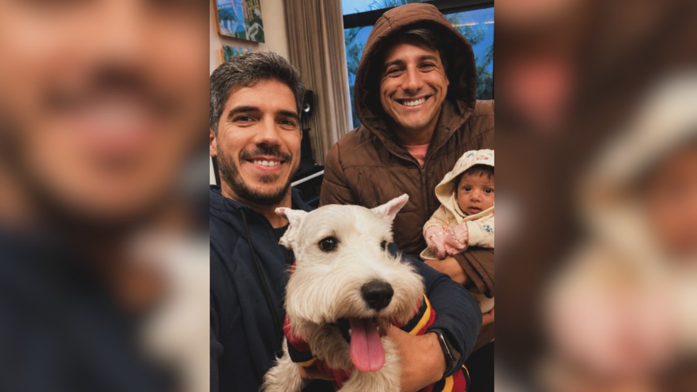 João Paulo Lefundes (à esquerda) e o marido Marcel de Ávila (à direita) com a filha do casal, Marina, e o cachorro Tião — Foto: Reprodução/Instagram