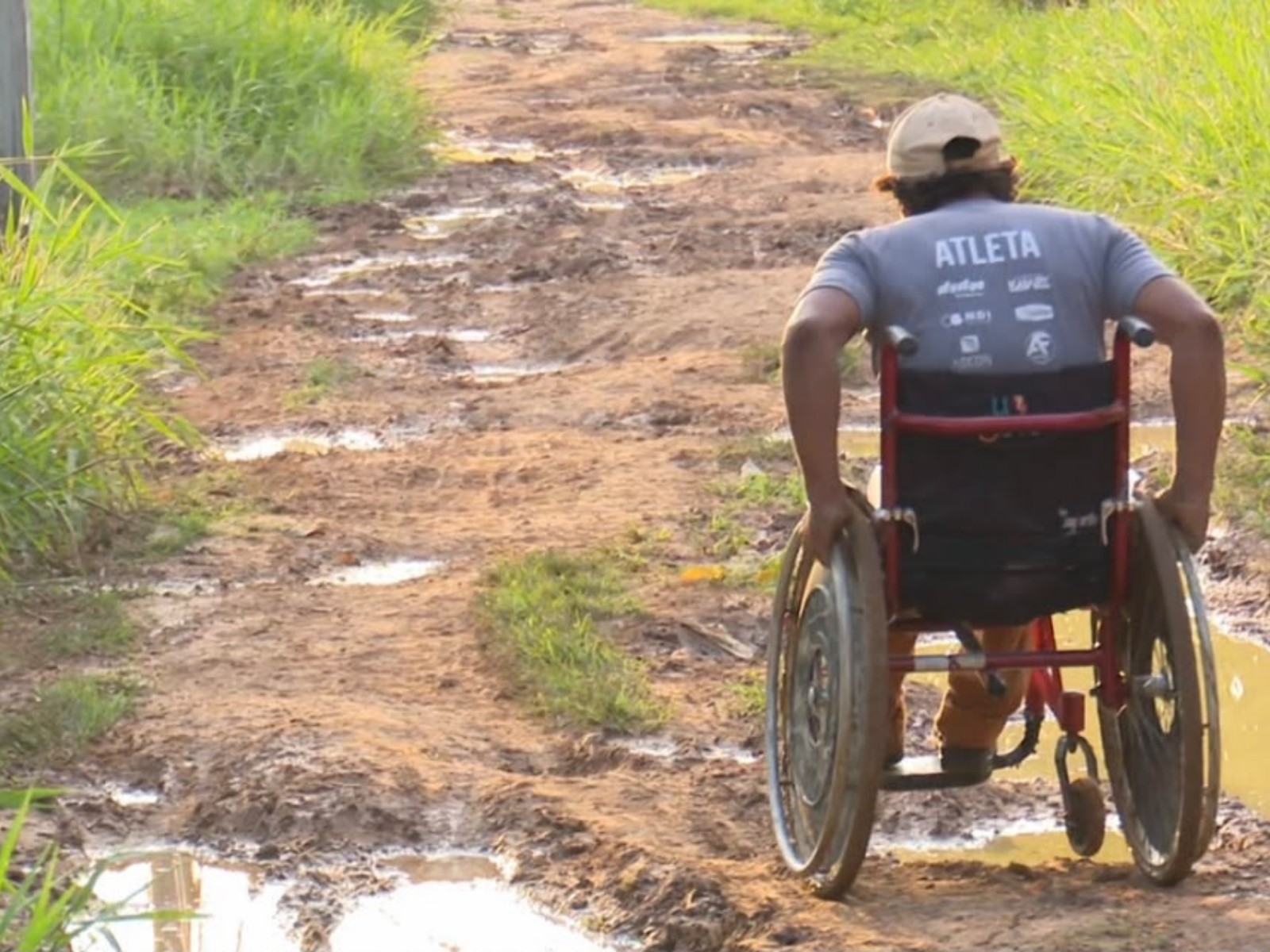 VÍDEO: Cadeirante atravessa rua com lama e buracos para chegar em via pavimentada no Acre