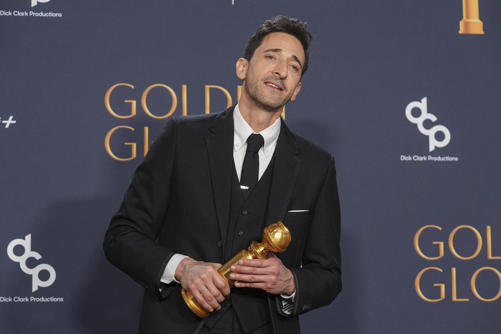 Adrien Brody posa com troféu ao ganhar como melhor ator de filme de drama por 'O brutalista' no Globo de Ouro 2025 — Foto: Chris Pizzello/AP