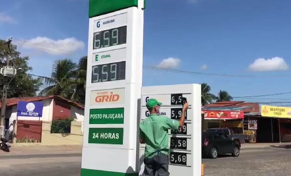 Frentista muda preço da gasolina em placa de posto de combustíveis em Natal — Foto: Emerson Medeiros/Inter TV Cabugi