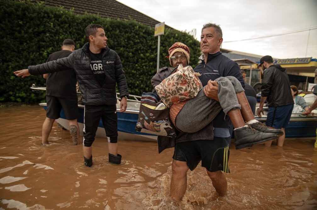 Pessoas são resgatadas de uma área inundada em Porto Alegre, Rio Grande do Sul, Brasil, em 4 de maio de 2024. — Foto: Carlos Fabal / AFP