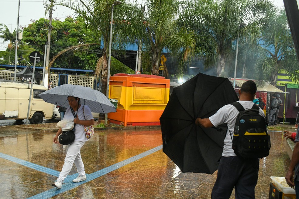 Pedestres se protegem da chuva na Zona Leste de SP na quinta-feira (8) — Foto: Edi Sousa/Ato Press/Estadão Conteúdo