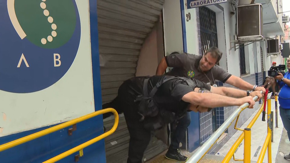Policiais arrombaram a porta para entrar no laboratório PCS Lab Saleme. — Foto: Reprodução/ TV Globo