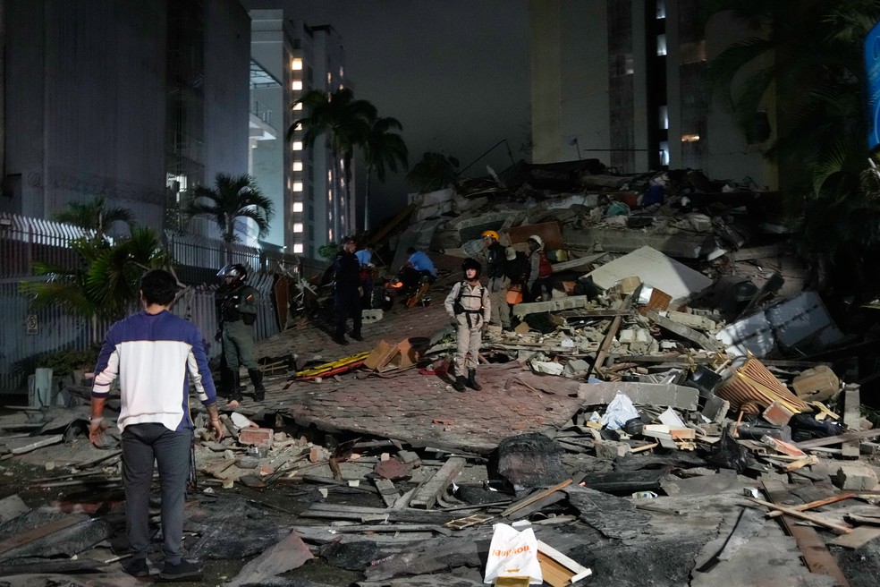 Pessoas caminham entre escombros ap&oacute;s um terremoto em Caracas, Venezuela, em 24 de junho de 2026 &mdash; Foto: Ariana Cubillos/AP Photo