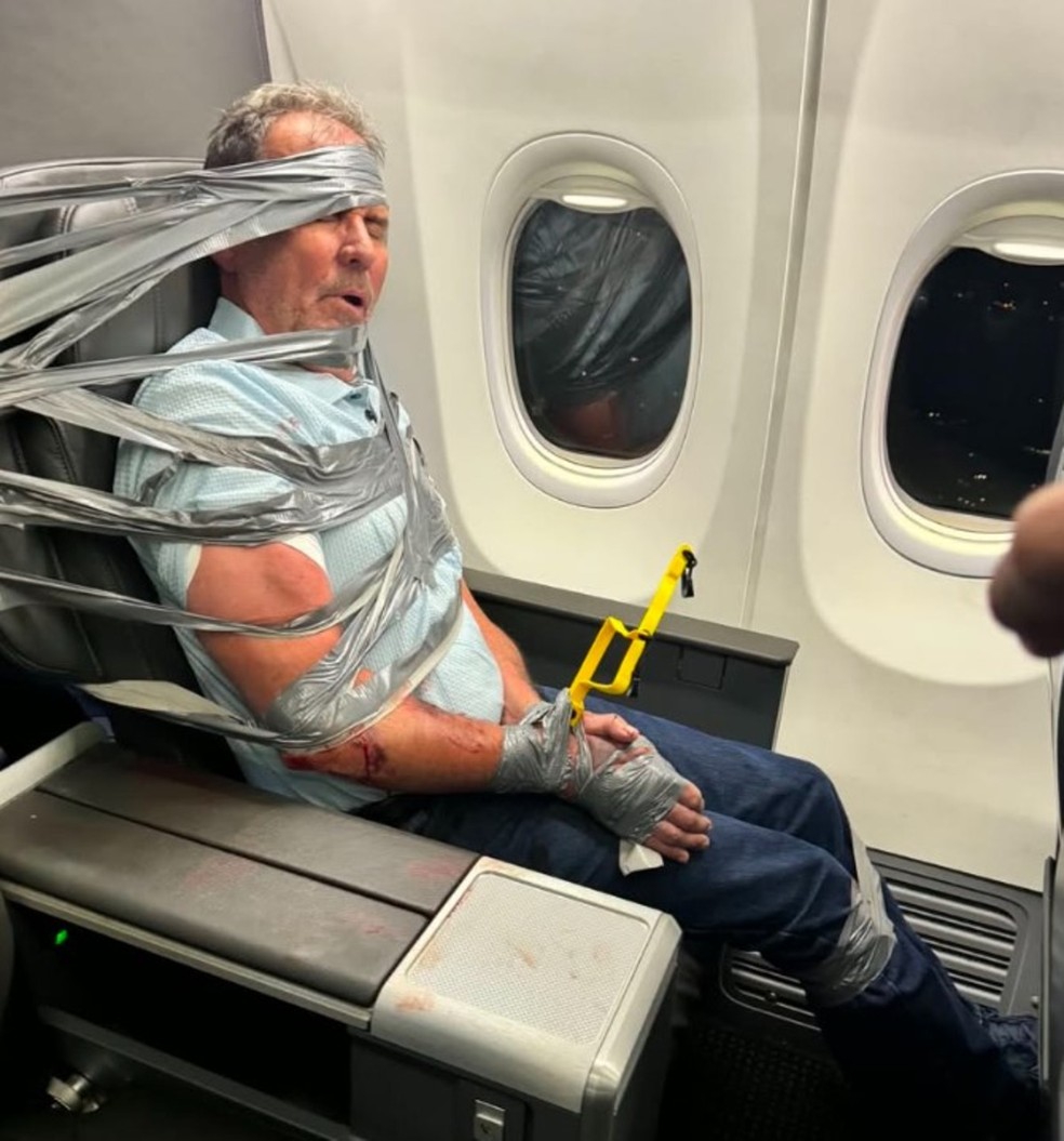Homem é amarrado a poltrona de avião após gritar e proferir xingamentos racistas e homofóbicos durante voo entre Dallas e Nova Jersey, nos EUA — Foto: Reprodção/Redes sociais