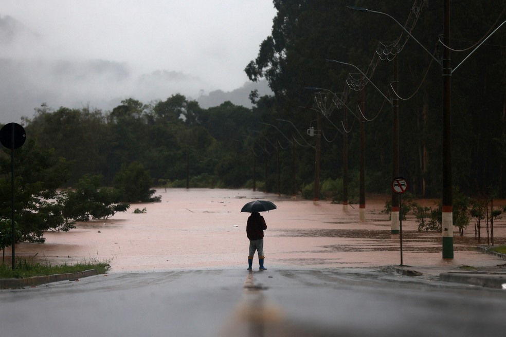 Homem observa estrada inundada perto do rio Taquari durante temporal na cidade de Encantado, no Rio Grande do Sul — Foto: Diego Vara/Reuters