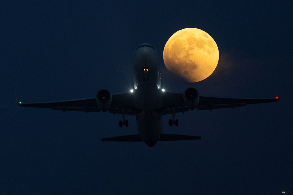 Avi�o comercial decola enquanto a Lua ganha tons avermelhados no in�cio do eclipse lunar, em San Diego, na Calif�rnia, nesta quinta-feira (27). � Foto: Mike Blake/Reuters