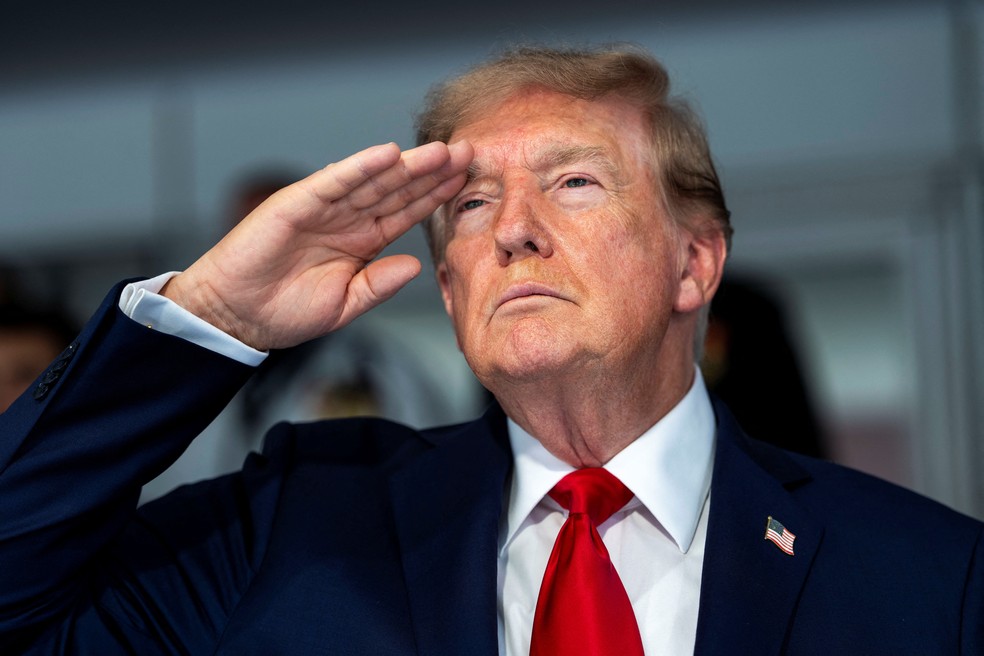 O presidente Donald Trump durante o hino nacional na largada da corrida Freedom 250 Grand Prix nas ruas de Washington, DC, domingo, 23 de agosto de 2026. — Foto: Doug Mills/Pool via REUTERS