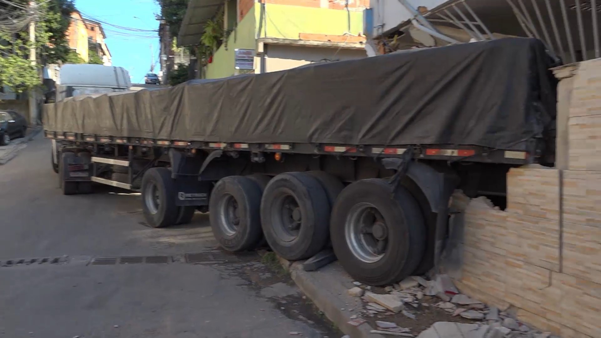 Carreta carregada com 25 toneladas de aço desce ladeira de ré e bate em casa na Serra