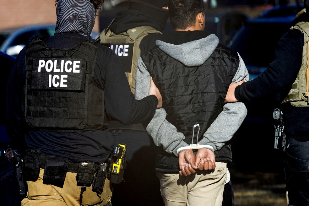 Agentes do Serviço de Imigração e Alfândega detêm um homem após realizar uma batida no complexo de apartamentos Cedar Run em Denver — Foto: REUTERS/Kevin Mohatt