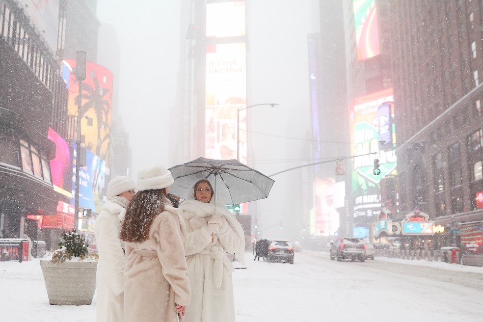 Pedestres na Times Square, no domingo (25), em Nova York, durante tempestade de neve — Foto: AP Photo/Heather Khalifa