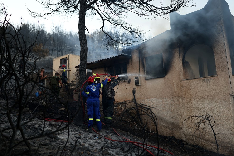 Bombeiros apagam chamas em casa na ilha de Salamina, na Grécia — Foto: REUTERS/Stelios Misinas