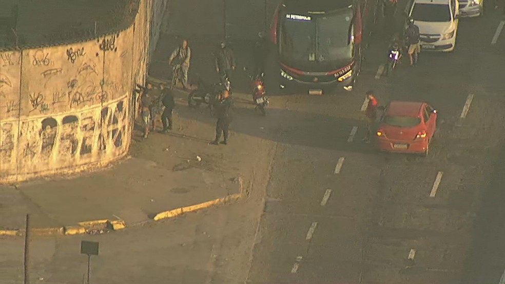 Ocupantes de carro vermelho foram revistados pelos policiais — Foto: Reprodução/ TV Globo