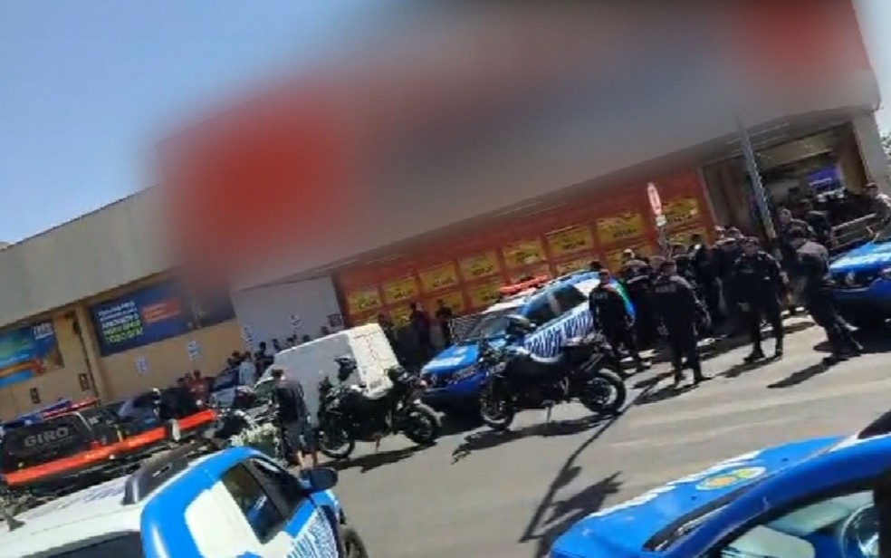 Aglomeração de pessoas e viaturas do lado de fora de supermercado onde homem morreu após ameaçar funcionários, em Goiânia — Foto: Reprodução/TV Anhanguera