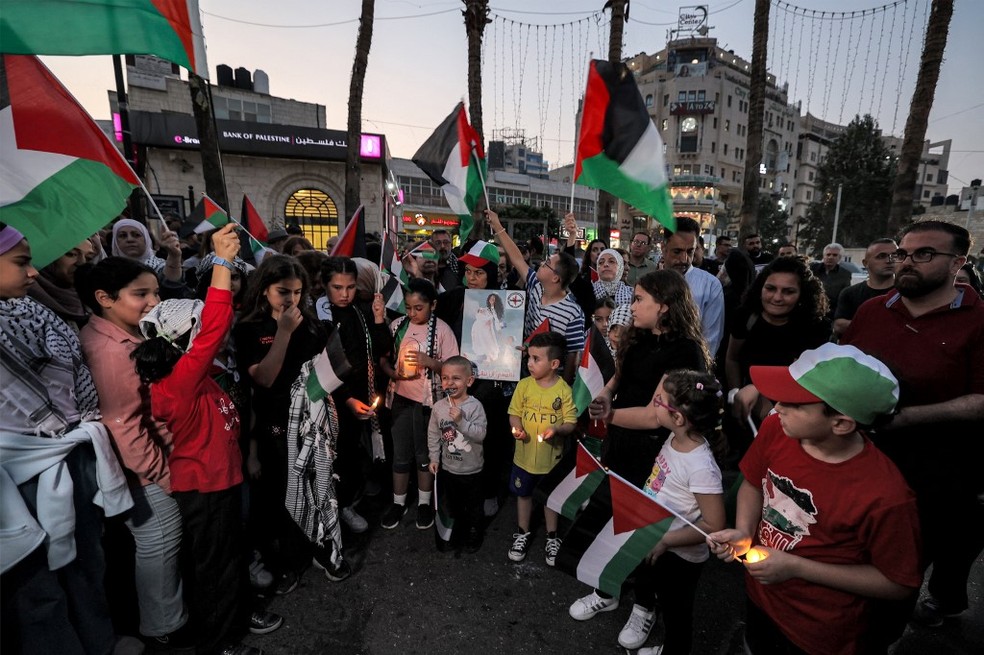 Pessoas se reúnem com bandeiras palestinas para uma manifestação de solidariedade ao povo da Faixa de Gaza em uma praça em Ramallah, na Cisjordânia ocupada, em 28 de outubro de 2023. — Foto: AFP