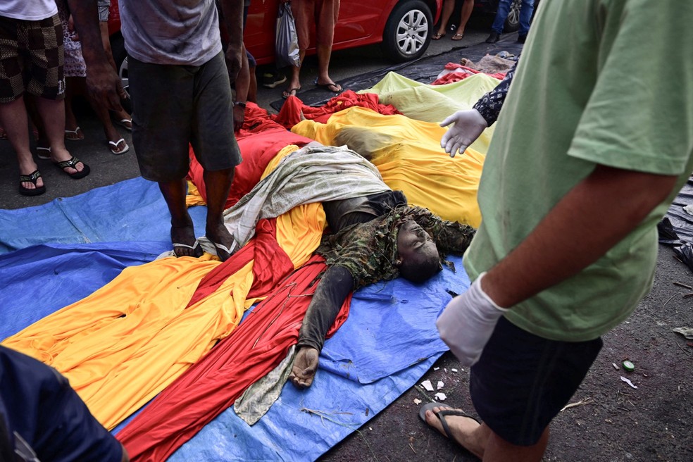 ATENÇÃO, IMAGENS FORTES: corpo é colocado em praça no Complexo da Penha no dia seguinte à megaoperação no Rio — Foto: Pablo Porciuncula/AFP