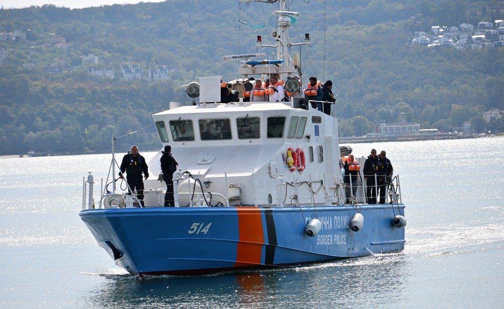 Uma embarcação da polícia de fronteira búlgara transportando tripulantes de um navio danificado em um ataque de drone, em 6 de outubro de 2026 — Foto: REUTERS/Petko Momchilov