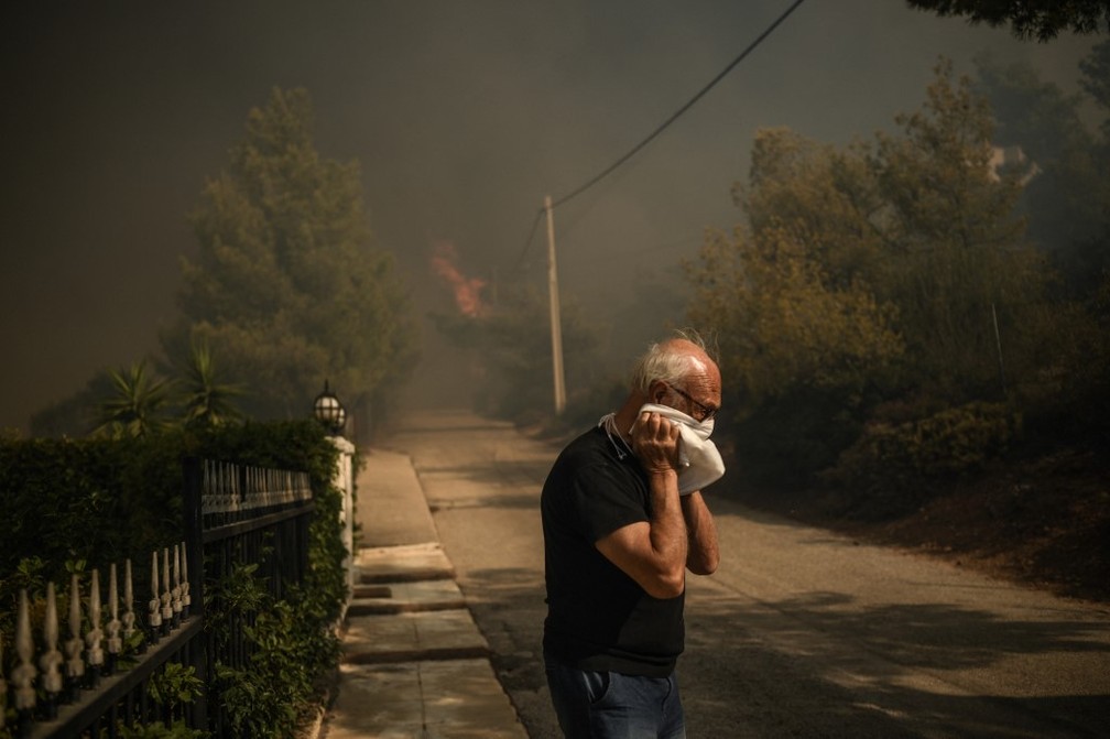 Grego sofre com fumaa dos incndios florestais — Foto: Angelos TZORTZINIS / AFP