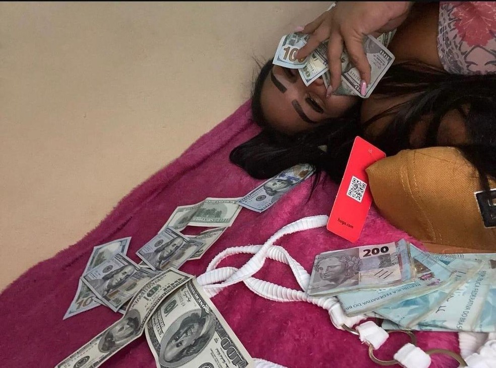 Em foto, ela aparece com notas de real e dólar na cama — Foto: Reprodução/Arquivo Pessoal