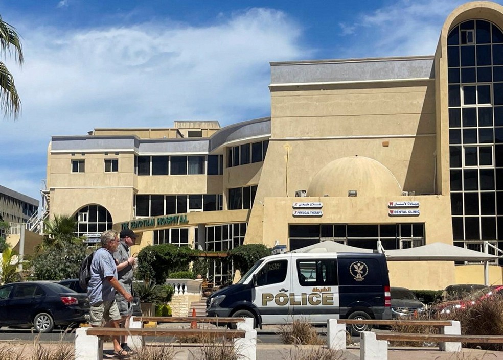 Pessoal caminham diante de hospital para onde corpos de turistas mortos em naufrágio de submarino no mar Vermelho foram levados, na cidade de Hurghada, em 27 de março de 2025. — Foto: Reuters