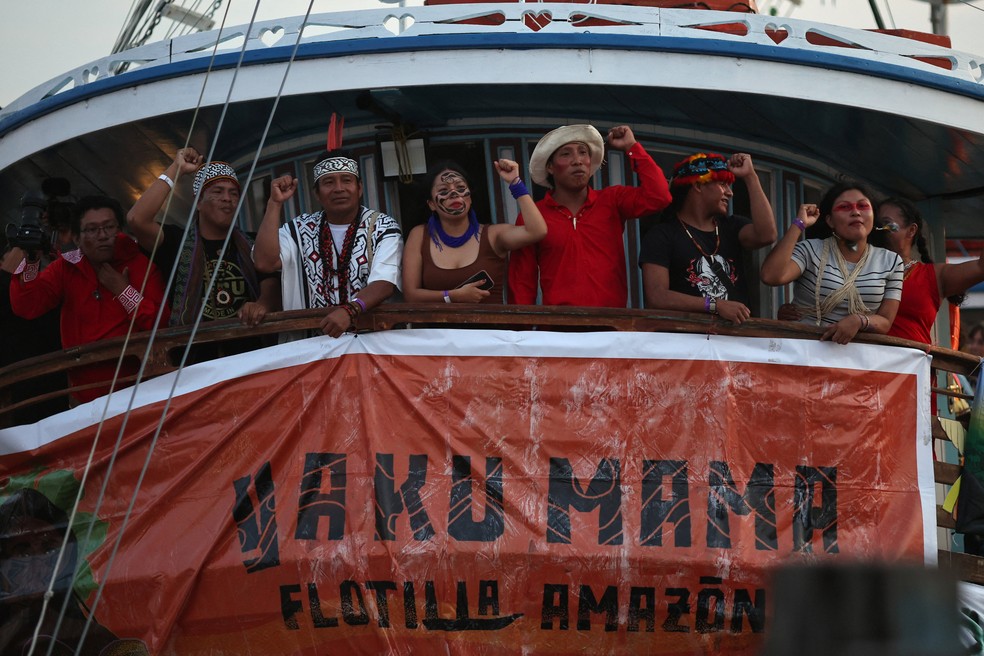 Pessoas reagem a bordo de um barco após a chegada, em Belém, de uma flotilha com representantes indígenas de toda a América Latina, antes da Conferência das Nações Unidas sobre Mudança do Clima (COP30), no Brasil, em 9 de novembro de 2025. — Foto: REUTERS/Adriano Machado