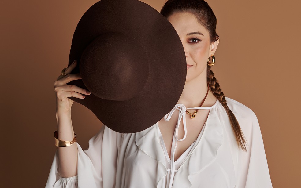 A especialista em moda Mariana Campos segura chapu em outro estilo para compor look inspirado na moda sertaneja  Foto: rico Andrade