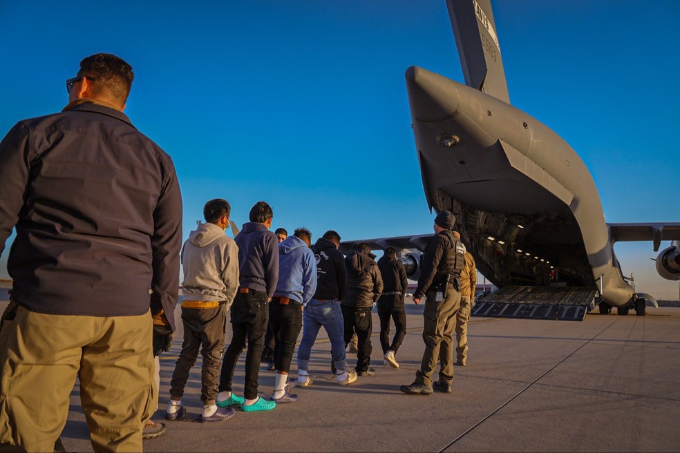 Imigrantes em processo de deportação são levados a avião militar dos EUA, em janeiro de 2025. — Foto: Divulgação/Casa Branca
