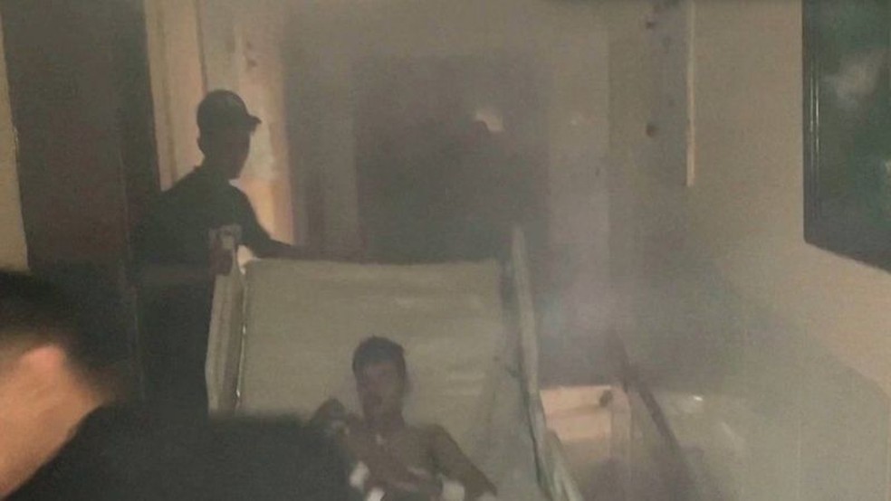 Médicos transportam paciente por um corredor cheio de fumaça dentro do hospital Al-Shifa após ataque israelense — Foto: MINISTÉRIO DA SAÚDE DE GAZA/REUTERS  via BBC Brasil