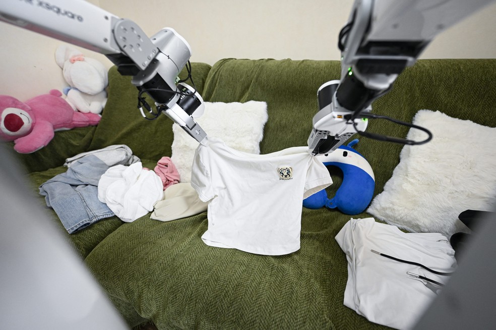 Foto tirada em 21 de maio de 2026, mostra um robô da X Square dobrando roupas na casa de um cliente em Pequim — Foto: WANG ZHAO/AFP