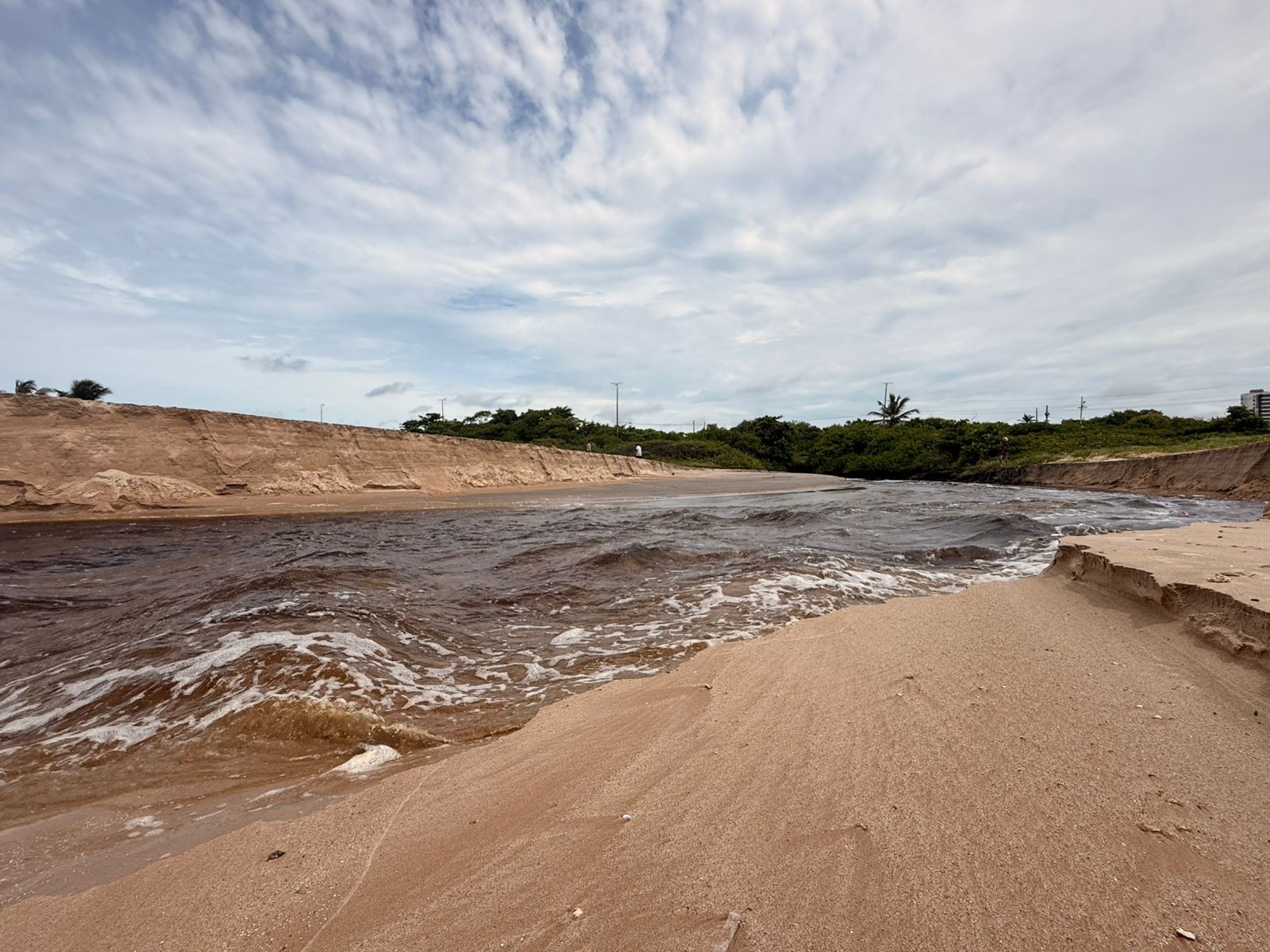 'Enxurrada' de água escura e com mau cheiro é registrada desaguando em praia da grande João Pessoa; VÍDEO