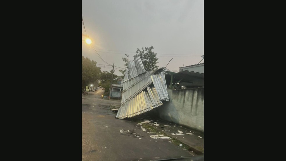 Em Ricardo de Albuquerque, uma garagem foi destelhada por causa dos ventos fortes e atingiu parte de uma rua — Foto: Reprodução/ TV Globo