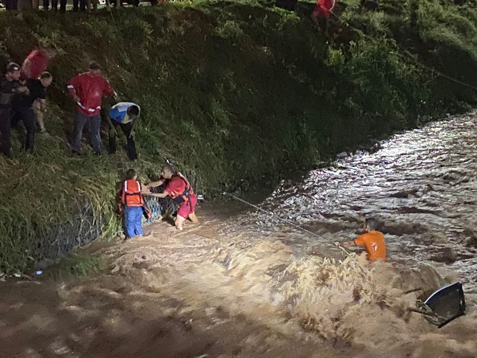 Carro com duas pessoas cai em córrego durante chuva, morador tenta ajudar e os três são resgatados pelos bombeiros em Lins — Foto: Defesa Civil/Divulgação