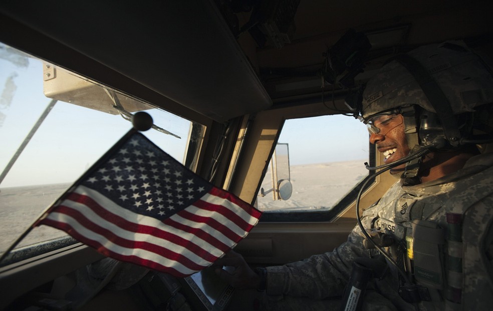 Soldado ostenta bandeirinha norte-americana durante retirada das tropas do Iraque. — Foto: Lucas Jackson / Reuters