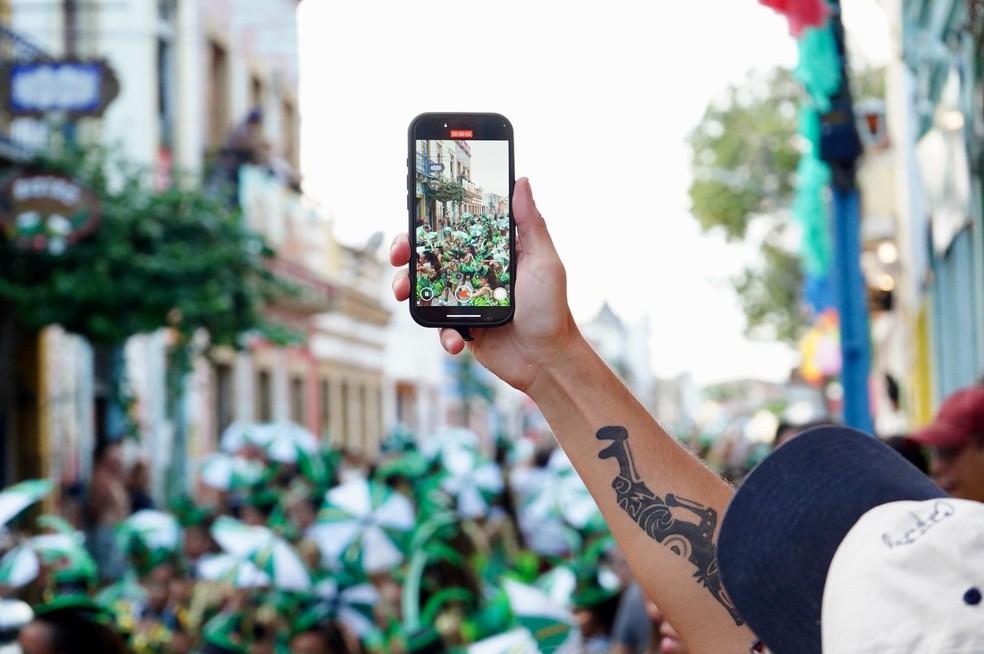 Folião fotografa carnaval de Olinda com um celular — Foto: Rafael Souza/g1