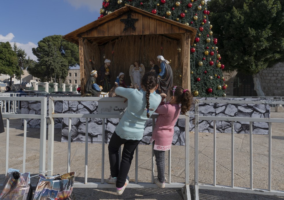 ARQUIVO - imagem de 23 de dezembro de 2020 mostra crianças olhando para o presépio na Praça da Manjedoura, em Belém, na Cisjordânia. — Foto: Nasser Nasser/AP Photo