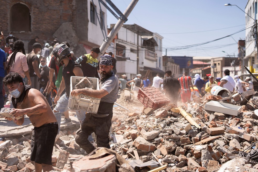 Moradores vasculham escombros de prédio que desabou em terremoto de magnitude de 7,4 em Cáli, na Colômbia, em 10 de agosto de 2026. — Foto: REUTERS/Camilo Rodriguez