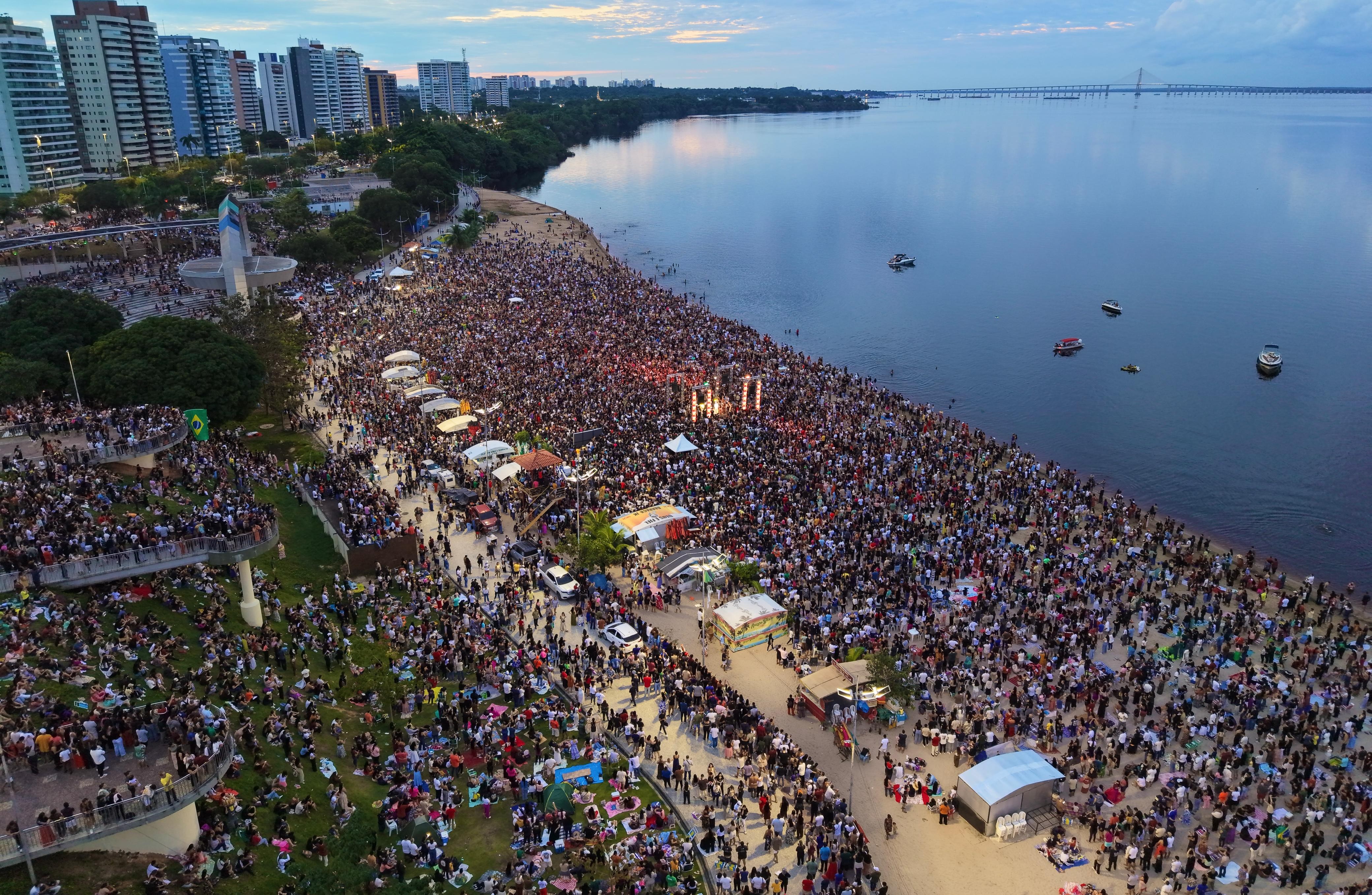 Evento religioso reúne milhares de fiéis ao amanhecer na Praia da Ponta Negra, em Manaus