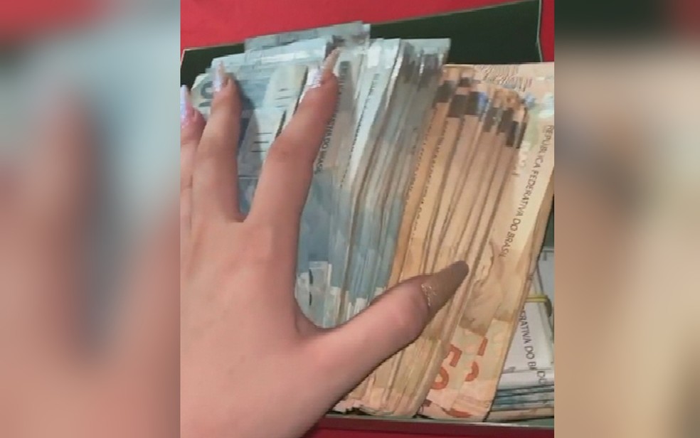 Influencer postou vídeo mostrando dinheiro que sacou em banco, em Goiânia, Goiás — Foto: Reprodução/TV Anhanguera