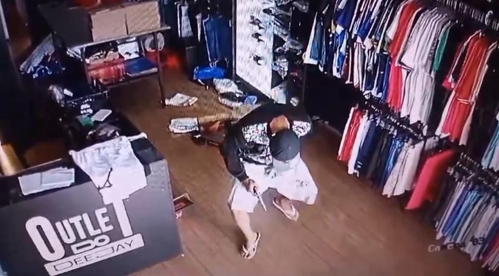 Após render o funcionário com uma arma, o trio roubou dpeças de roupas da loja. — Foto: Reprodução