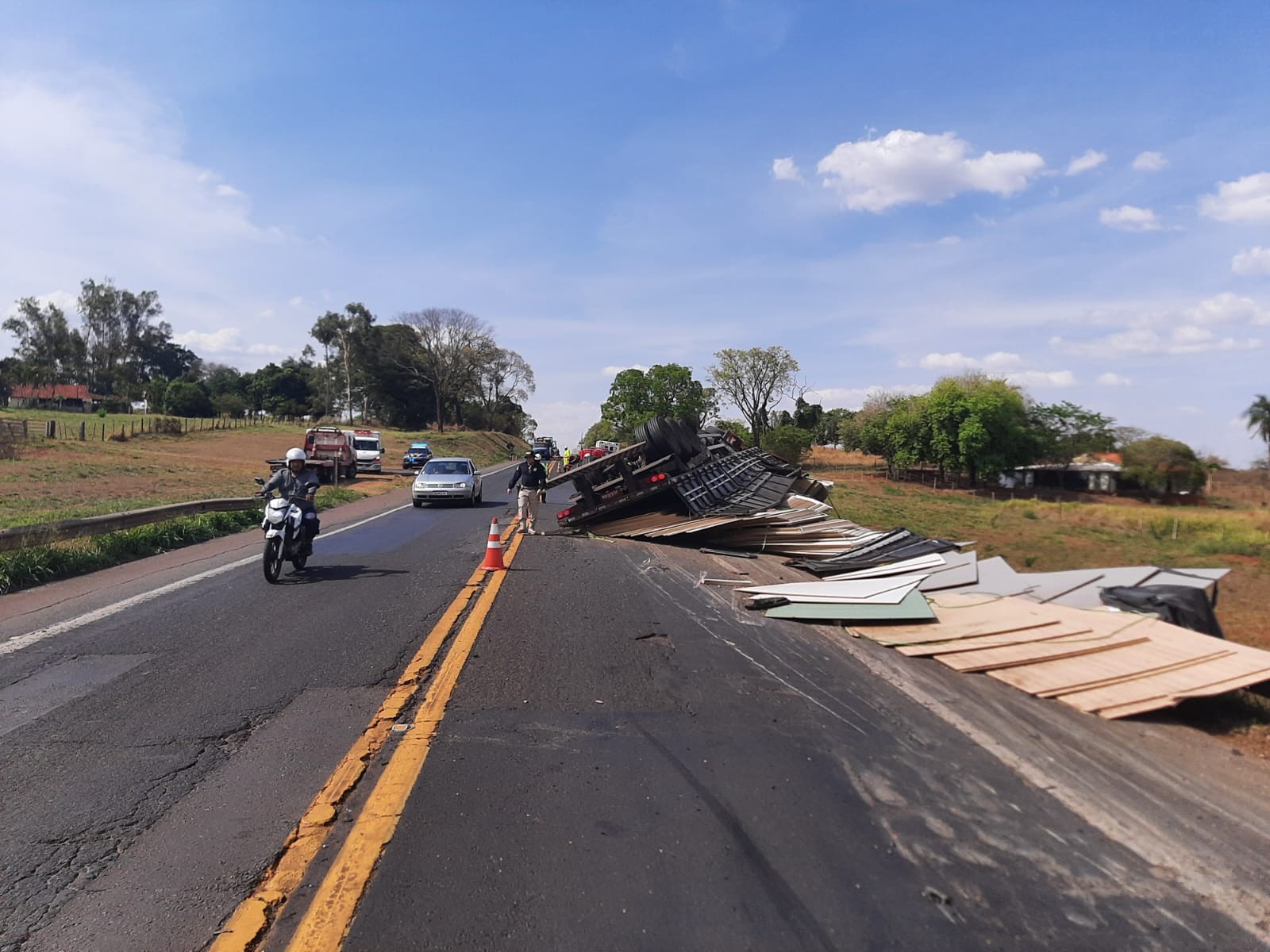 Motorista morre após carreta carregada com placas de madeira tombar na BR-153 