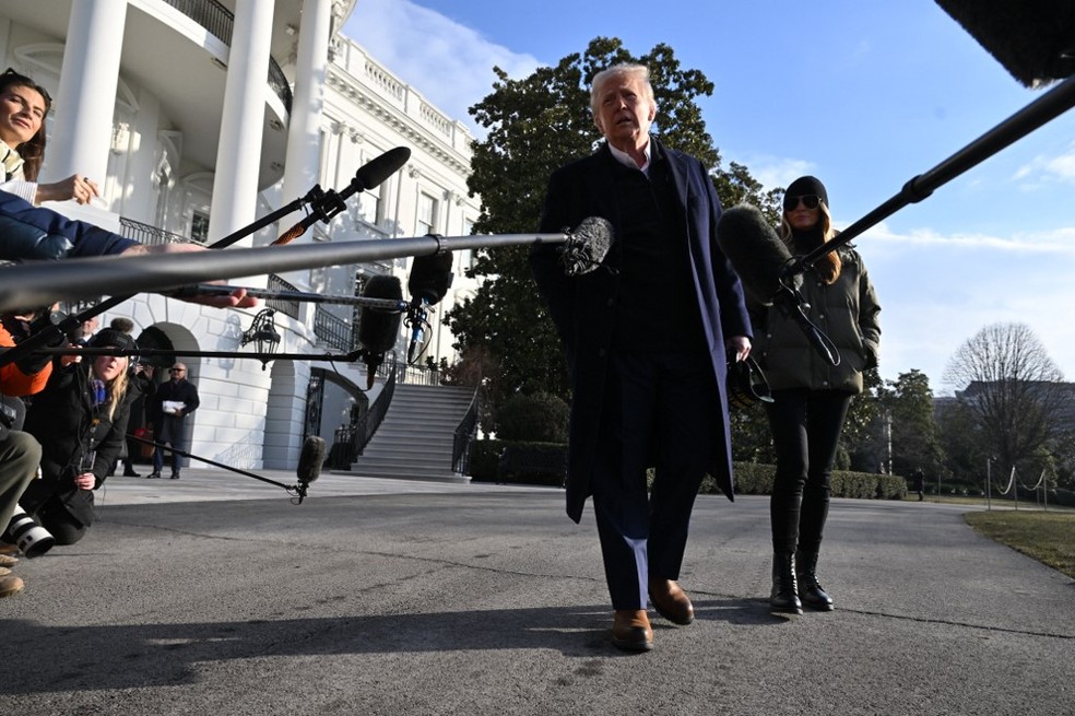 Donald Trump deixando a Casa Branca ao lado de Melania — Foto: ROBERTO SCHMIDT / AFP