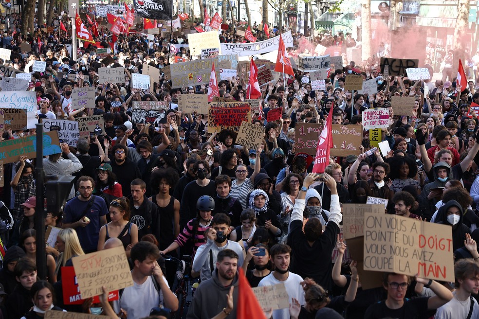 Manifestantes exibem cartazes e bandeiras durante uma manifestação de estudantes do ensino médio e universitário, apoiados pelo sindicato dos professores e pais de alunos, em Paris. — Foto: Abdul Saboor/Reuters