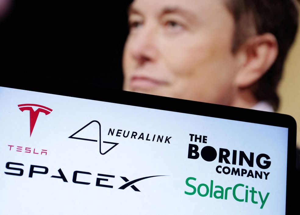 Logos da Tesla, Neuralink, SpaceX, The Boring Company e SolarCity aparecem em frente à foto de Elon Musk — Foto: REUTERS/Dado Ruvic/Ilustração/Foto de arquivo