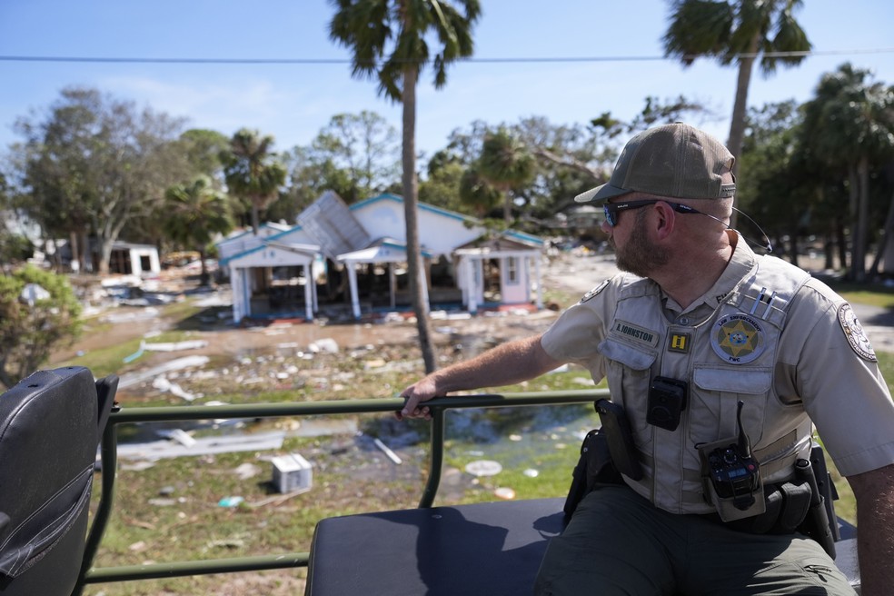 Policial diante de casa destruída pelo furacão Helene na Flórida nesta sexta — Foto: Gerard Herbert/AP